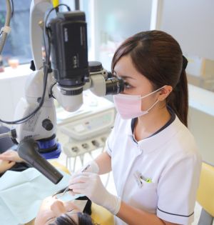 ツァイス社製マイクロスコープを設置した小机歯科医院の診療ユニットと、マイクロスコープを使って治療する歯科医師の様子